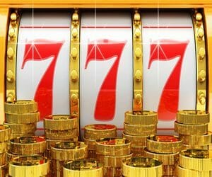 Jackpot, gambling gain, luck and success concept, closeup view of casino slot machine with winning event and gold coins in foreground